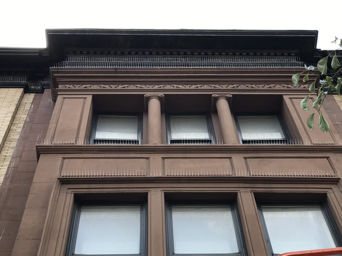 Bird spikes along the cornice and ledges of a Morningside Heights brownstone